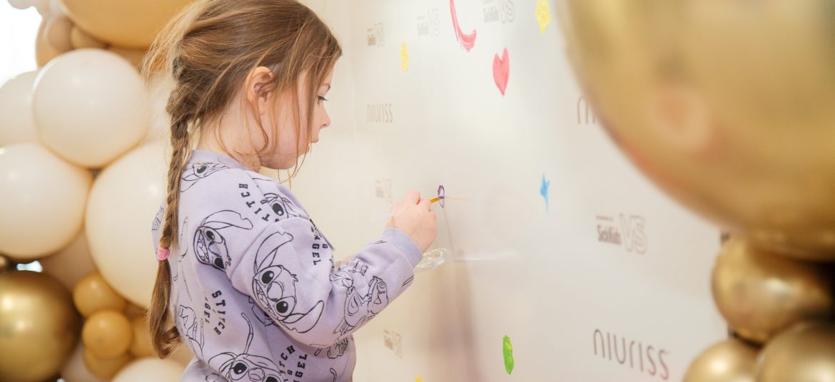 A young child paints on a wall