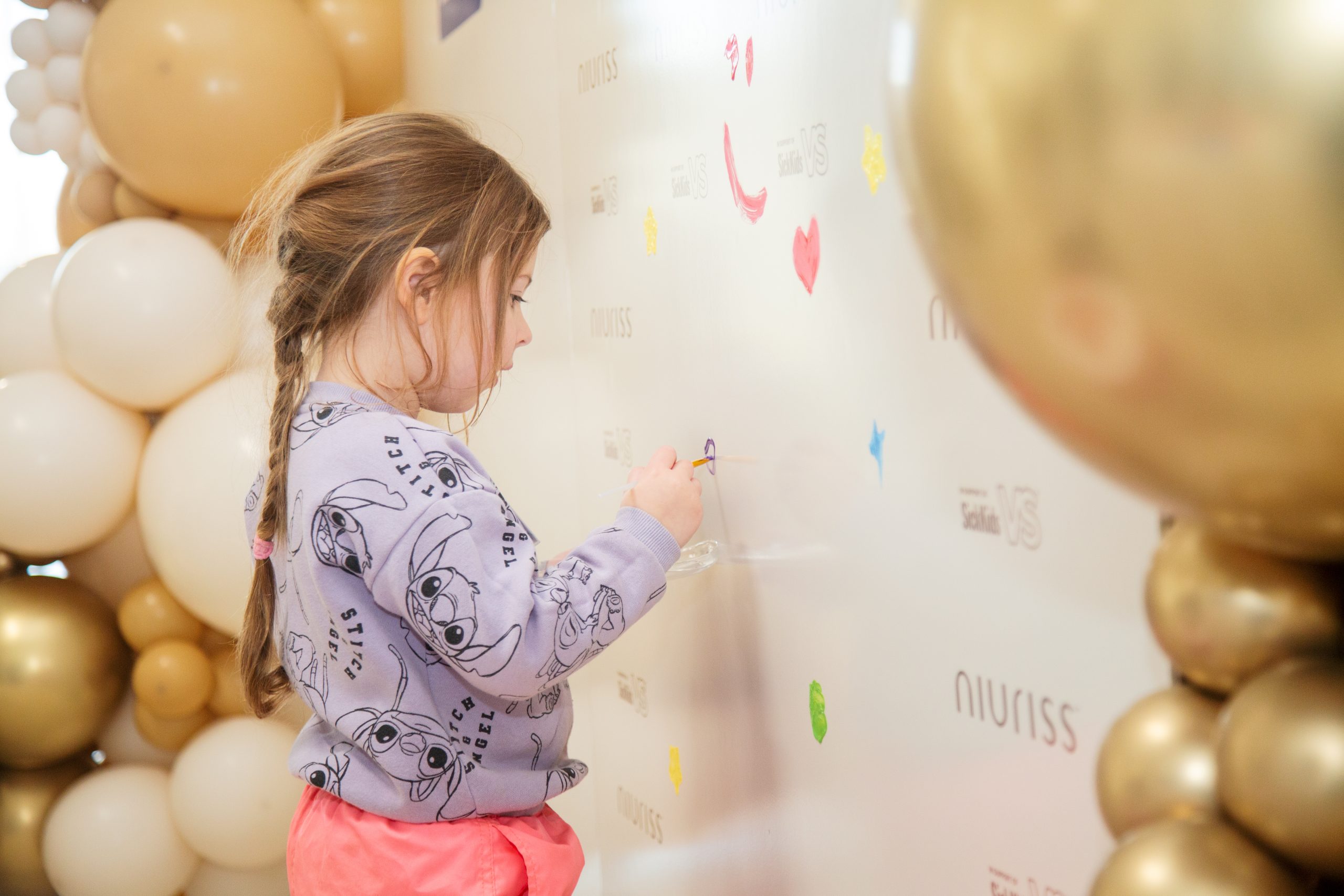 A young child paints on a wall